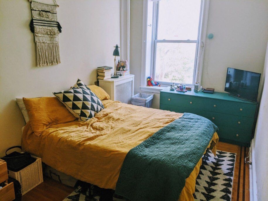 a bedroom with a bed and a dresser and a window