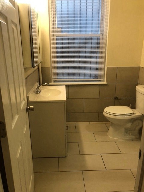 a bathroom with a toilet and a sink and a window
