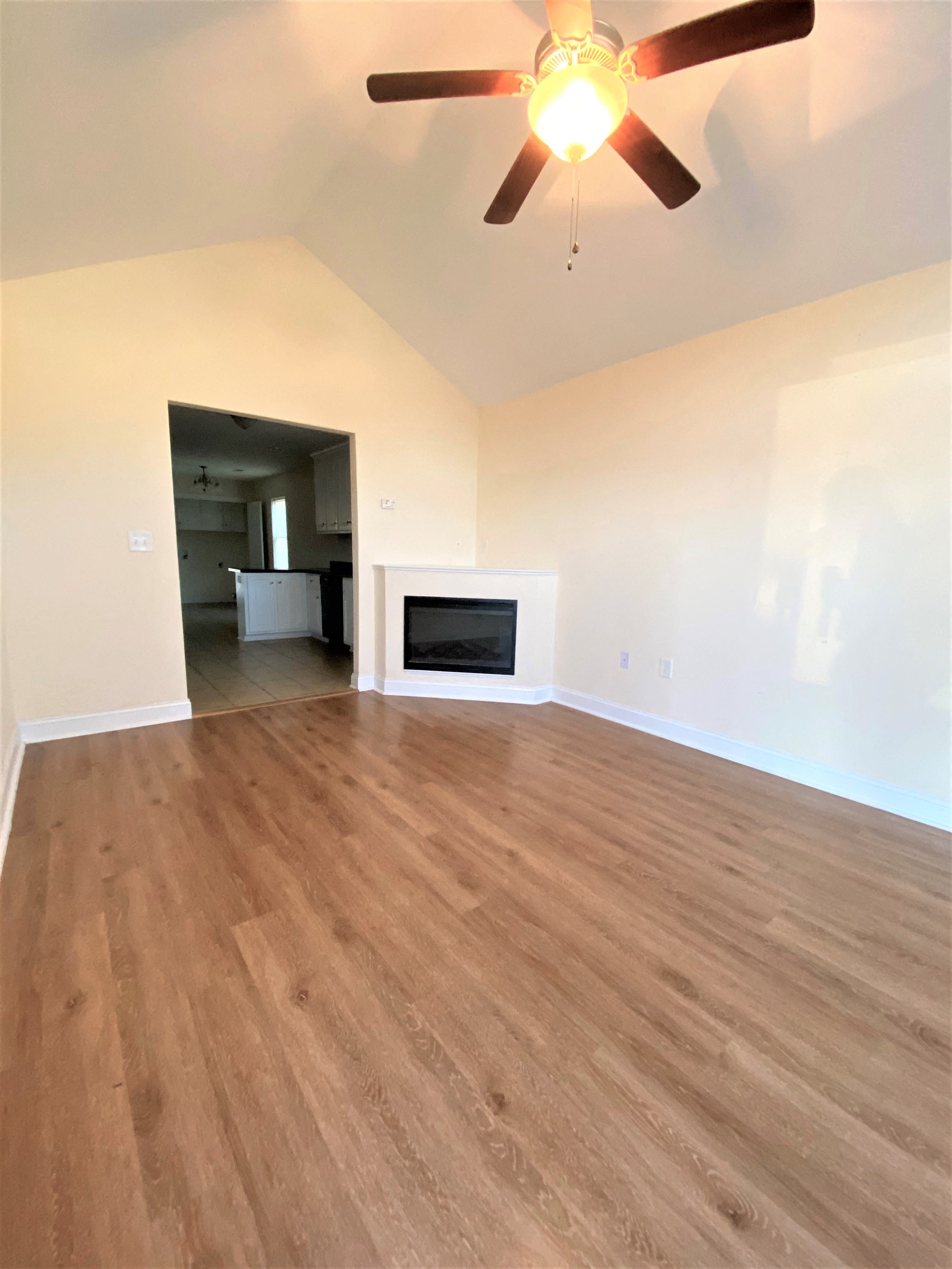 A room with a ceiling fan and a television.