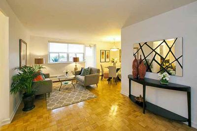 Bayview Apartments Cozy living area with spacious entrance. A asymmetric mirror hands on the wall above a sleek black table in Richmond Hill, ON
