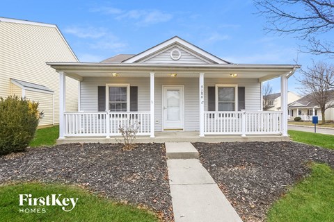 the front of a white house with a white front porch