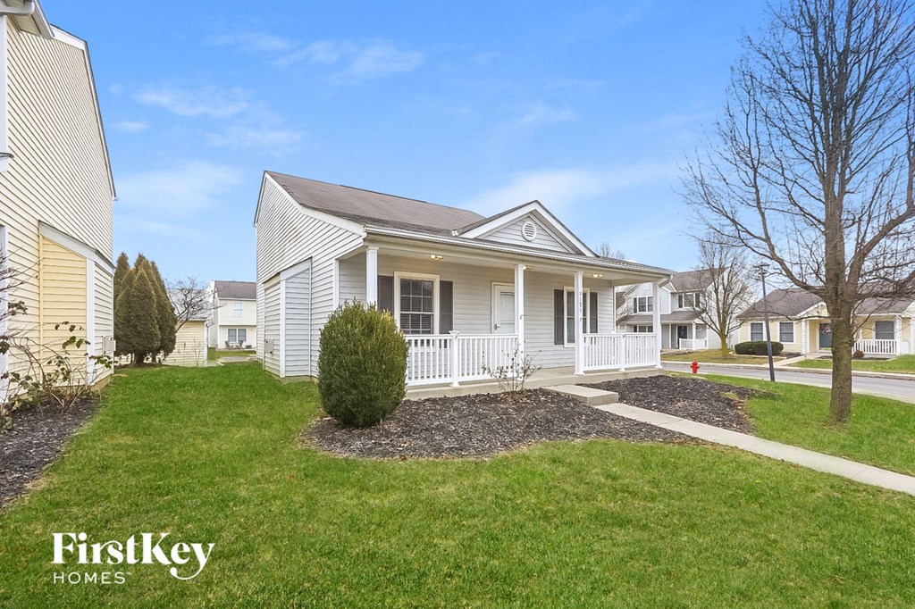 a white house with a lawn and a sidewalk