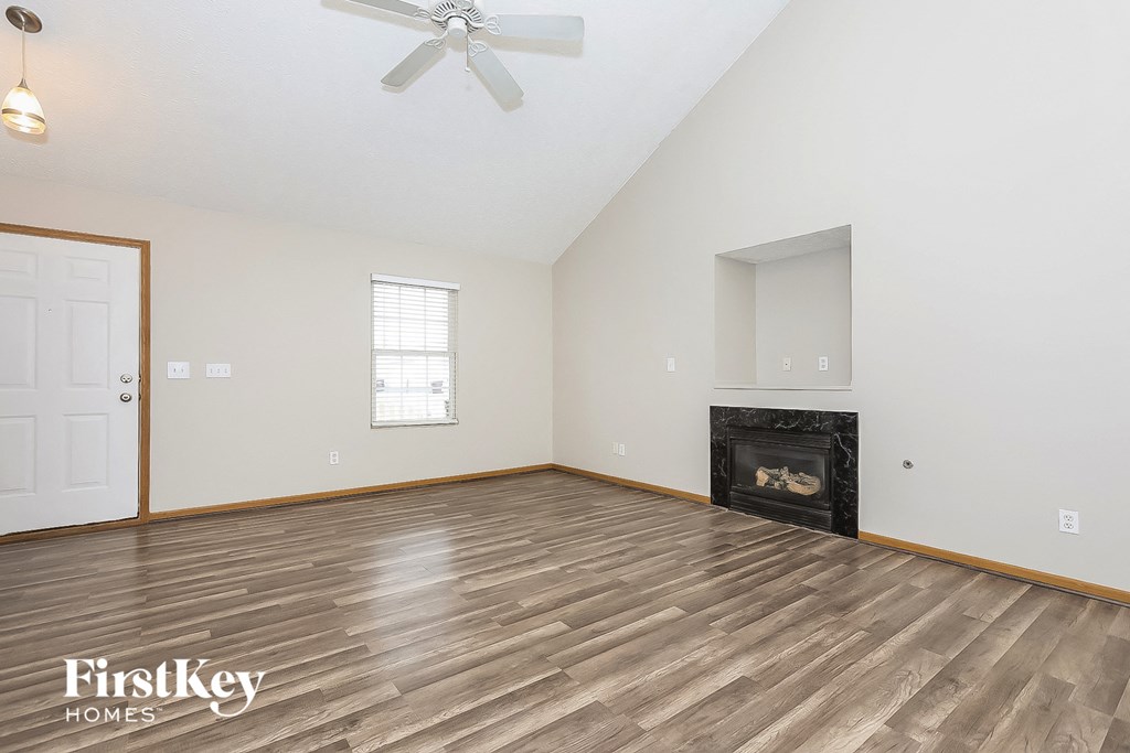 the living room with wood flooring and a fireplace