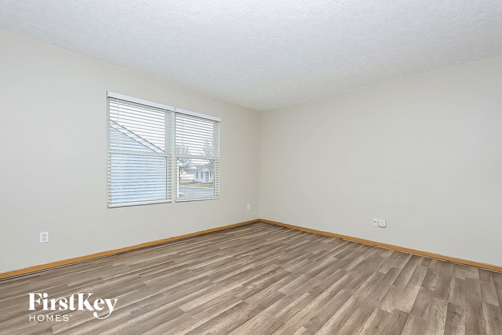 the living room of a house with wood floors and a window