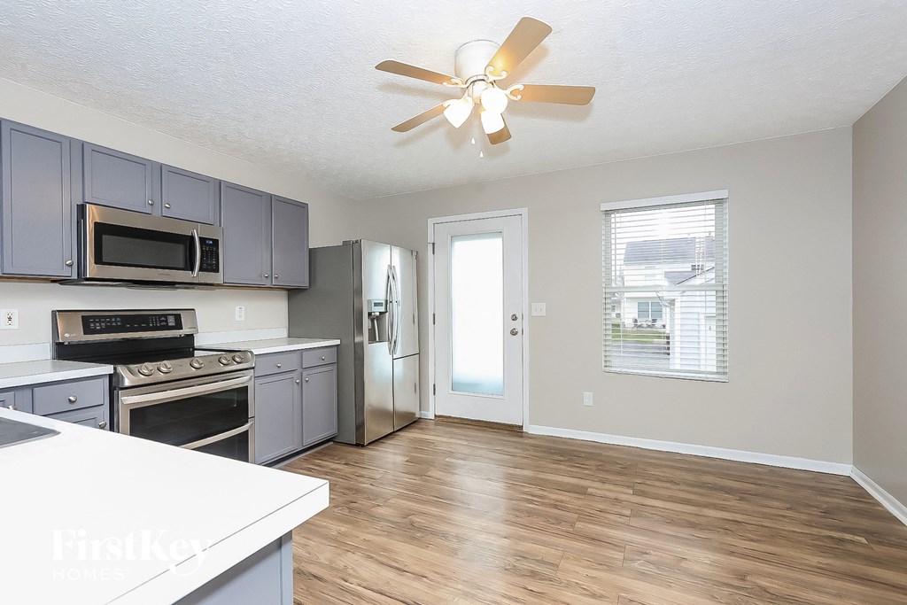 a kitchen with stainless steel appliances and a ceiling fan