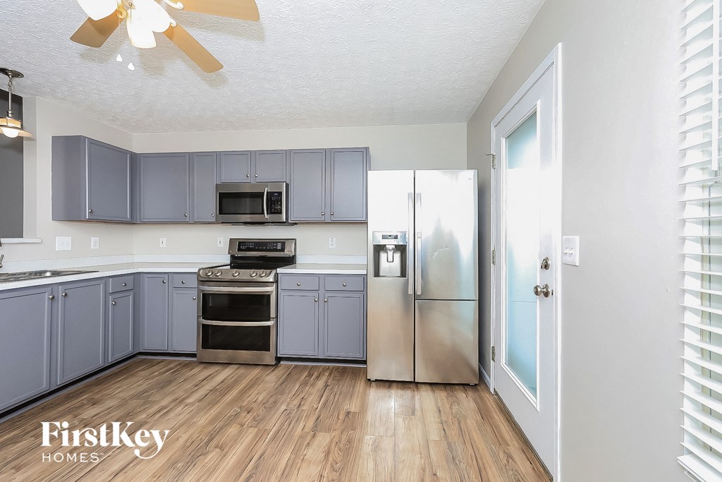a kitchen with stainless steel appliances and blue cabinets