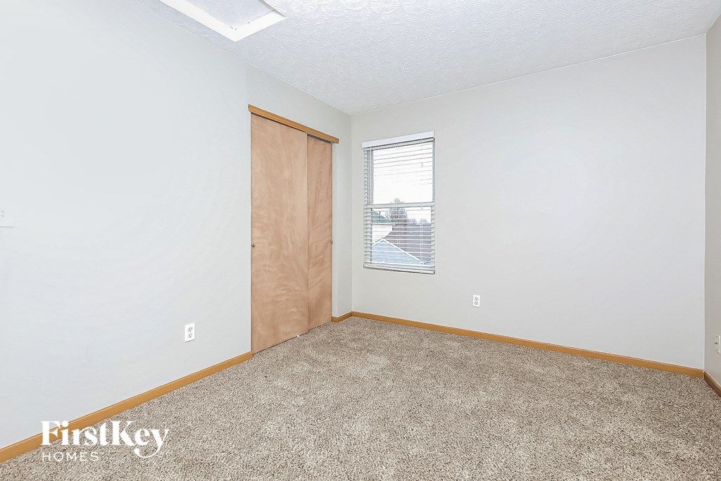 a bedroom with carpet and a door to a window