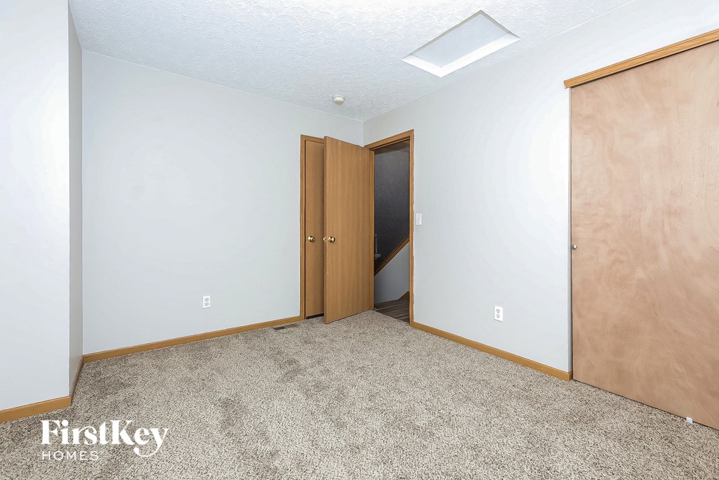 a bedroom with a closet and a door to a hallway
