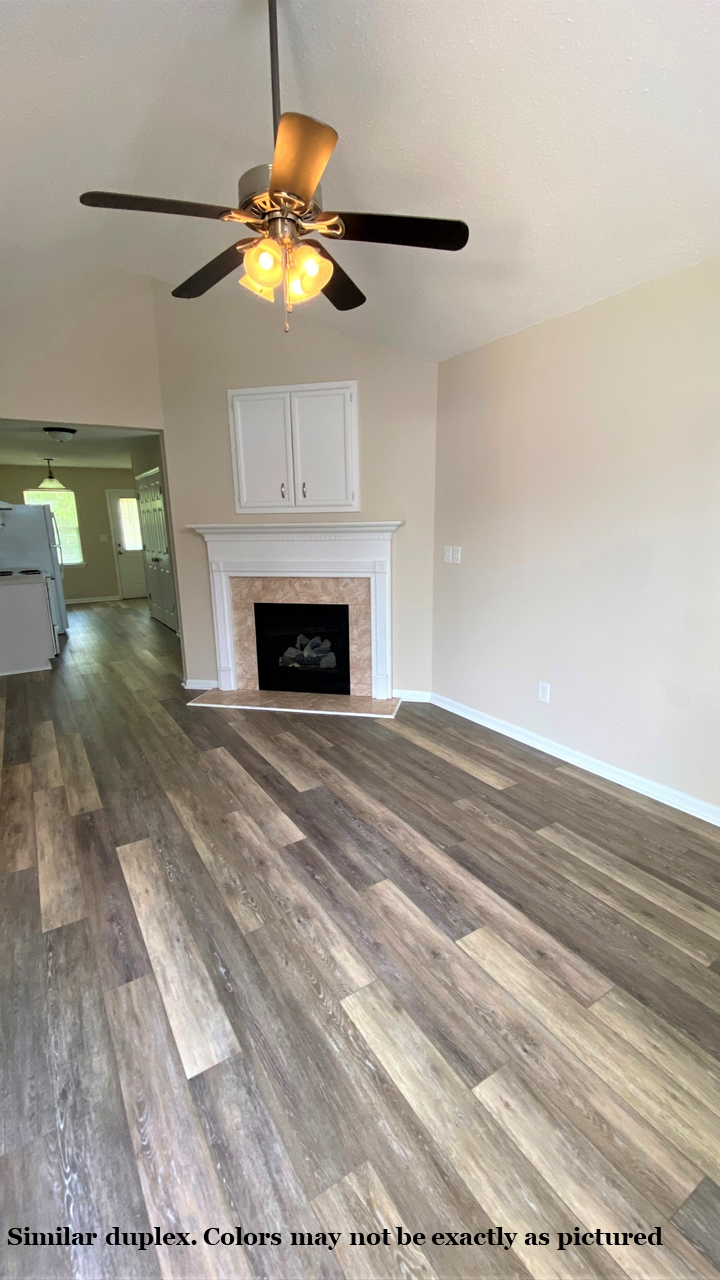 A room with a fireplace and a ceiling fan.