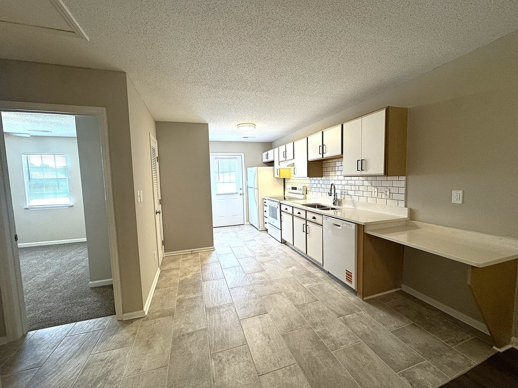 A kitchen with white cabinets and a countertop.