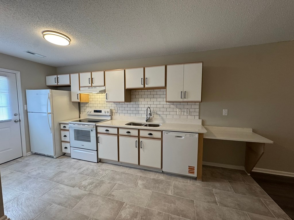 A kitchen with white appliances and cabinets.