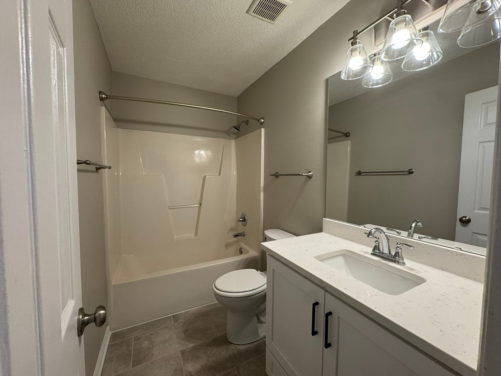 A bathroom with a toilet, sink, and shower.