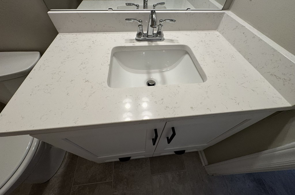 A white sink with a silver faucet in a bathroom.