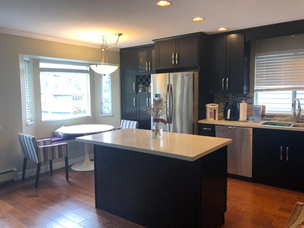 an image of a kitchen with black cabinets and a white counter top