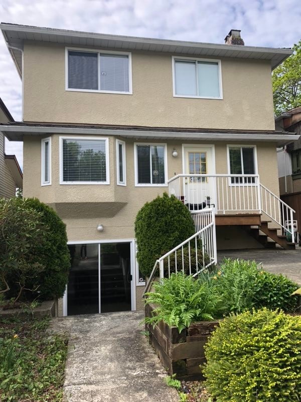 a tan house with a front porch and a driveway