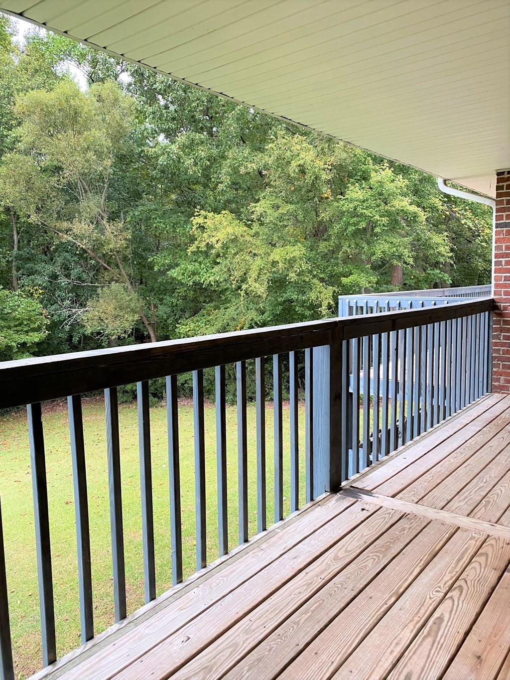 a balcony with a view of a yard and trees