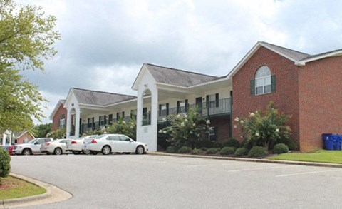 A red brick building with a white trim and a black awning.