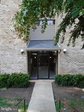 A building entrance with a metal gate and a brick wall.