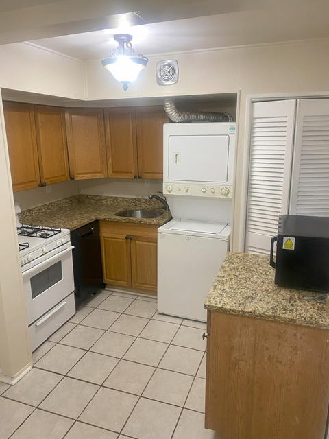 A kitchen with a white stove and a white dishwasher.