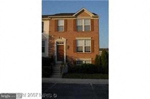 A red brick house with a white door and windows.