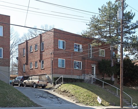 A red brick building with a truck parked in front.