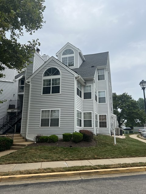 A two-story house with a grey siding exterior.