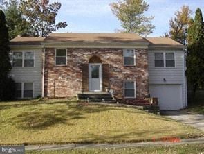 A house with a white garage door and a brown brick exterior.