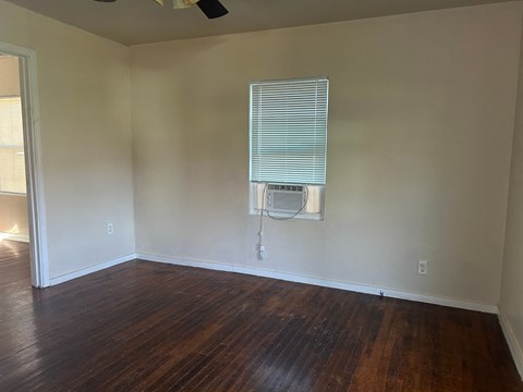 an empty room with wood floors and an air conditioner on the wall