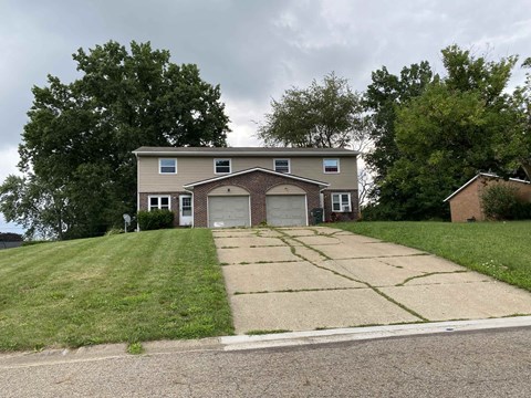 A house with a garage and a driveway in front of it.