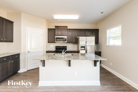 A kitchen with a granite countertop and a refrigerator.