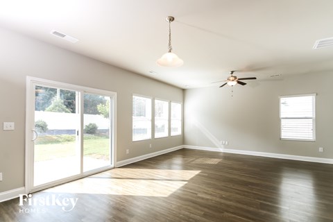 A spacious room with a ceiling fan and sliding glass doors.