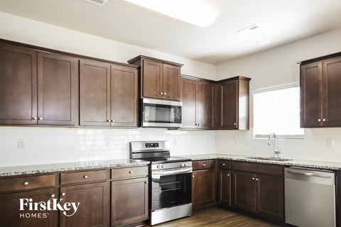 A kitchen with brown cabinets and a stove top oven.