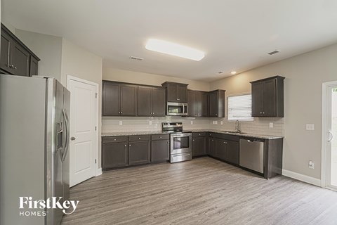 A kitchen with dark brown cabinets and a white fridge.