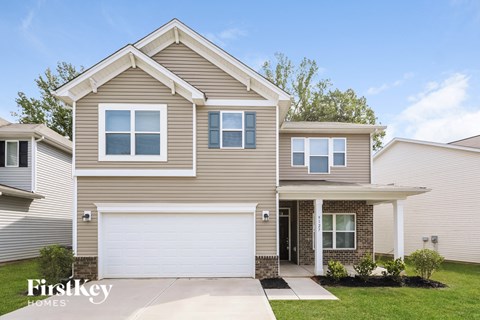 a tan house with a white garage door