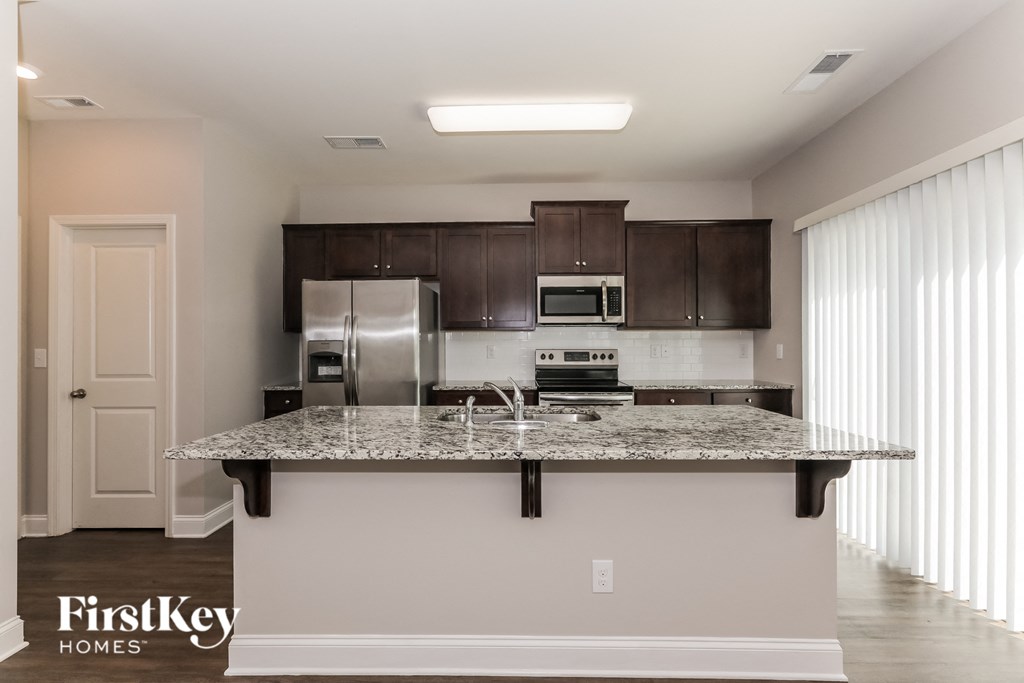 a kitchen with granite countertops and stainless steel appliances