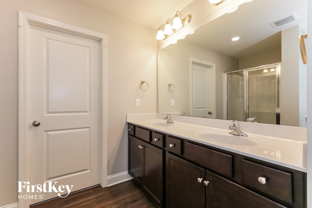 a bathroom with a sink and a mirror and a door to a closet