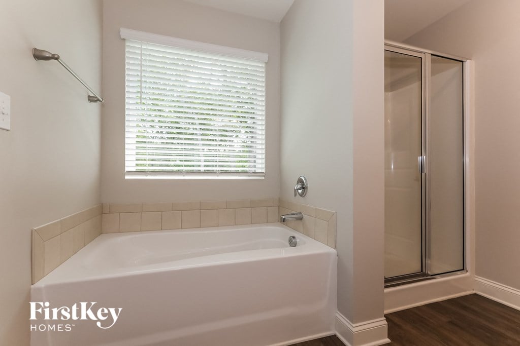 a bathroom with a large white tub and a shower