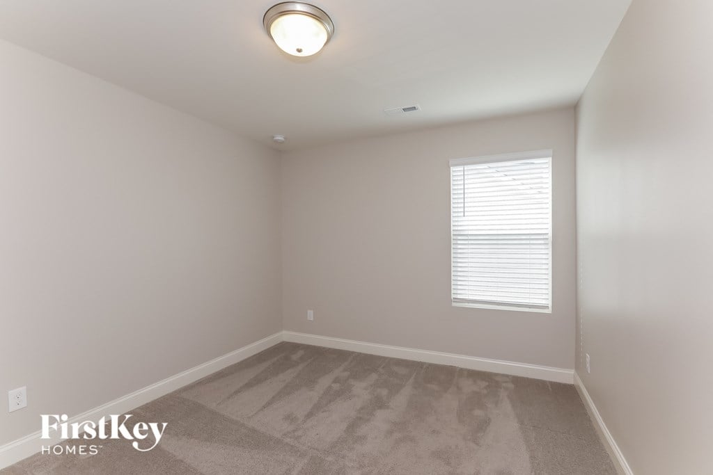 a bedroom with a carpeted floor and a window