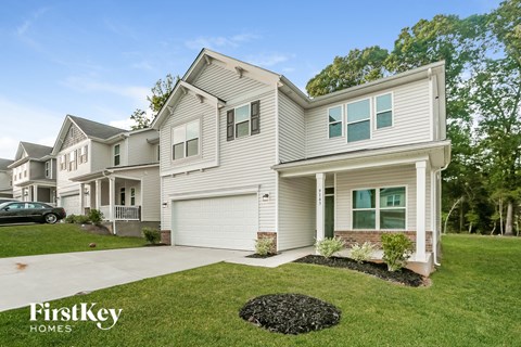 a white house with a driveway and a lawn