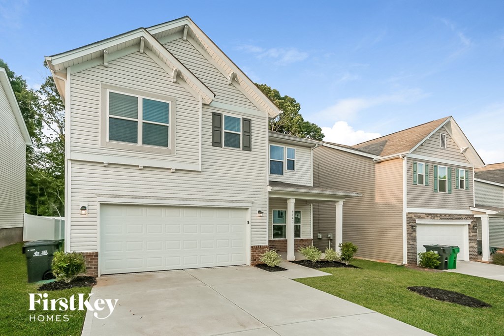 a beige and white house with a driveway