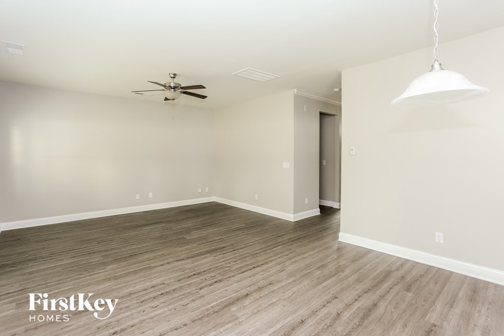a living room with wood flooring and a ceiling fan