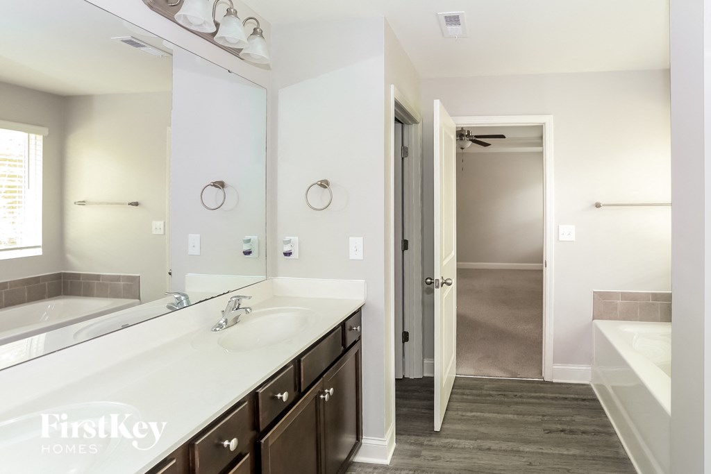 a bathroom with a large mirror and a sink and a shower