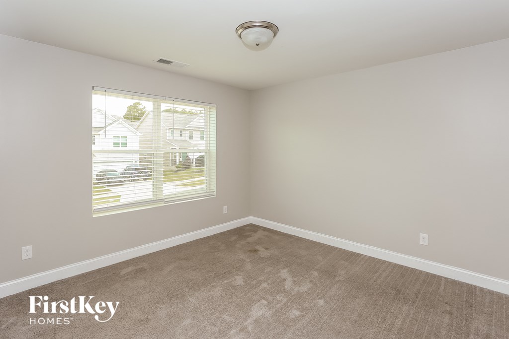 a bedroom with a carpeted floor and a large window
