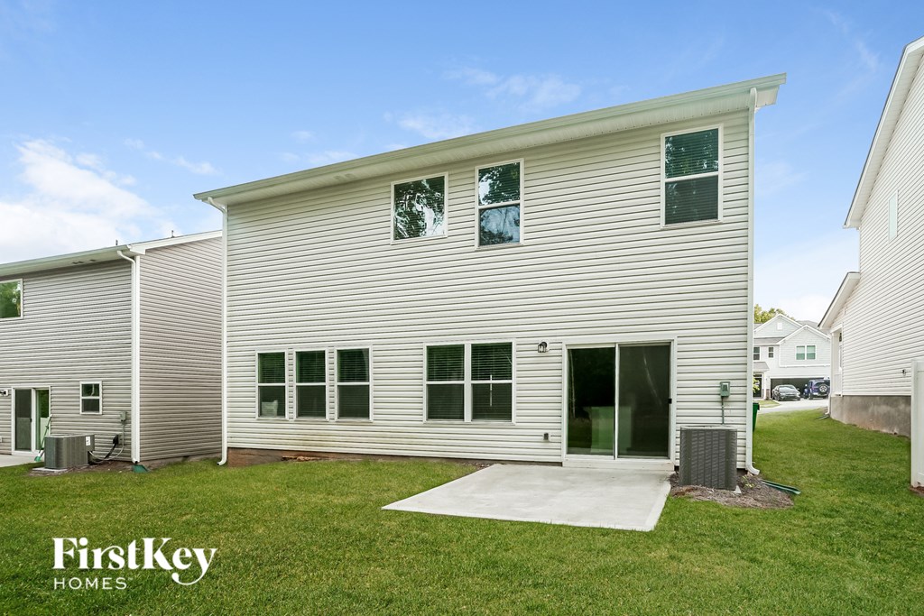 the exterior of a white house with a driveway and grass