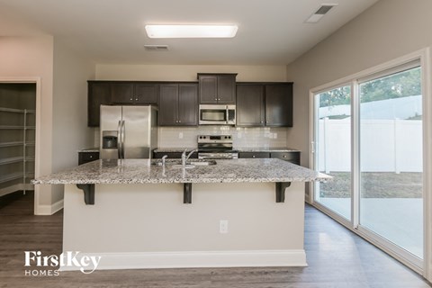 a kitchen with granite counter tops and black cabinets