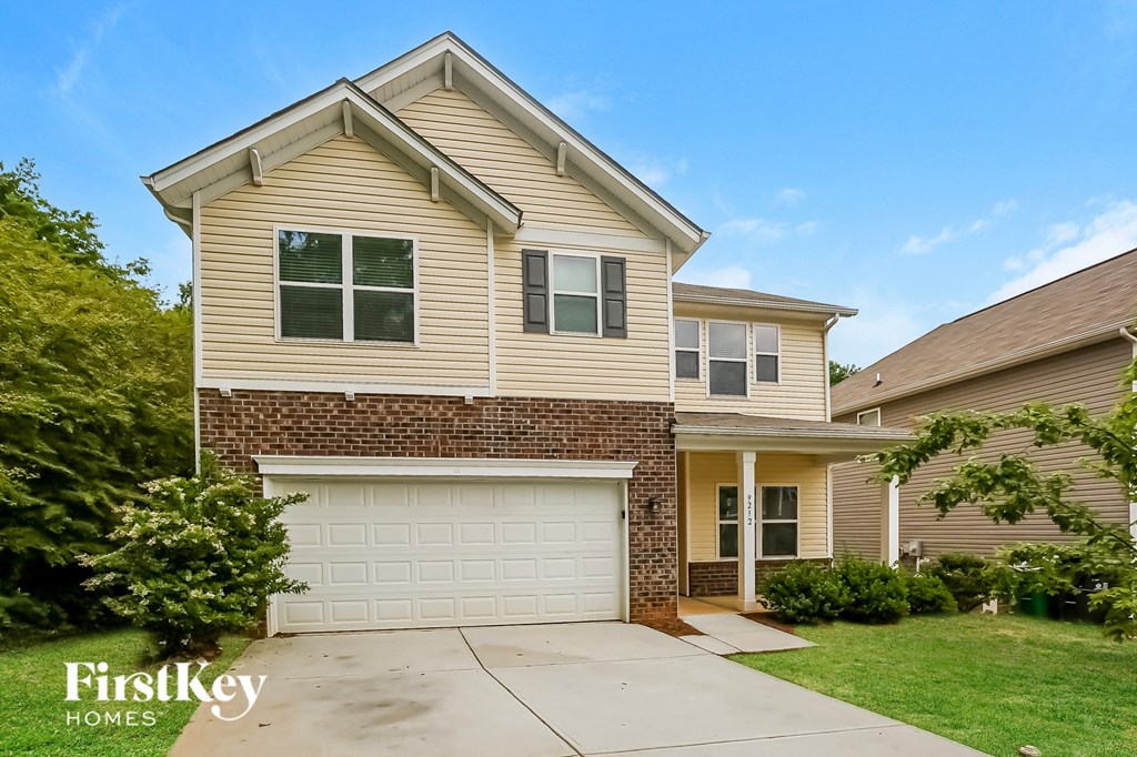 a tan house with a white garage door