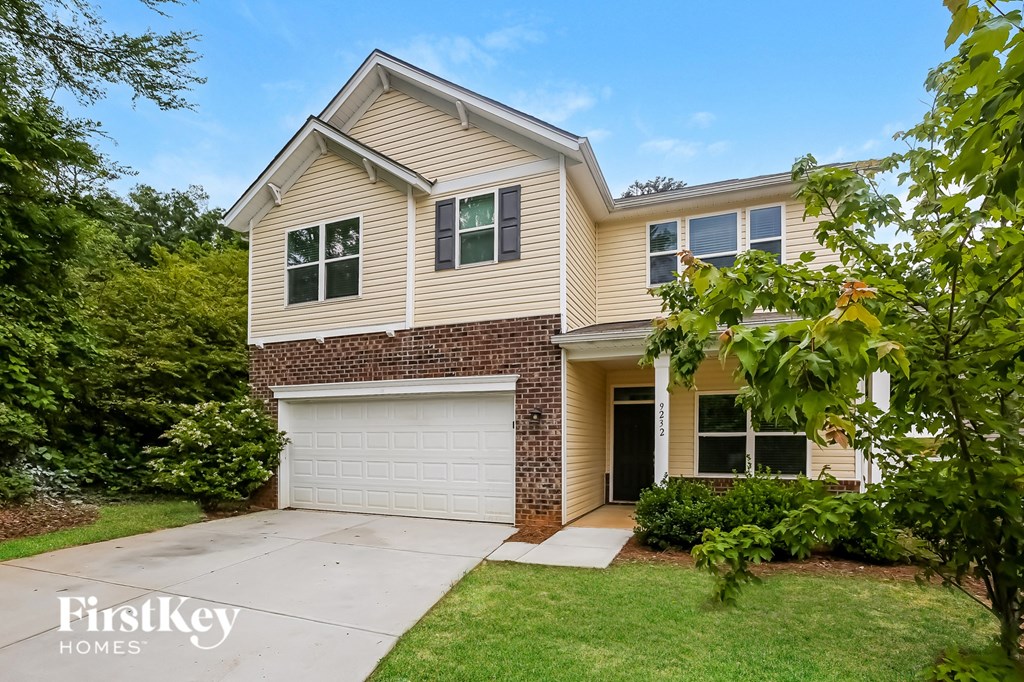 a beige and brick house with a white garage door