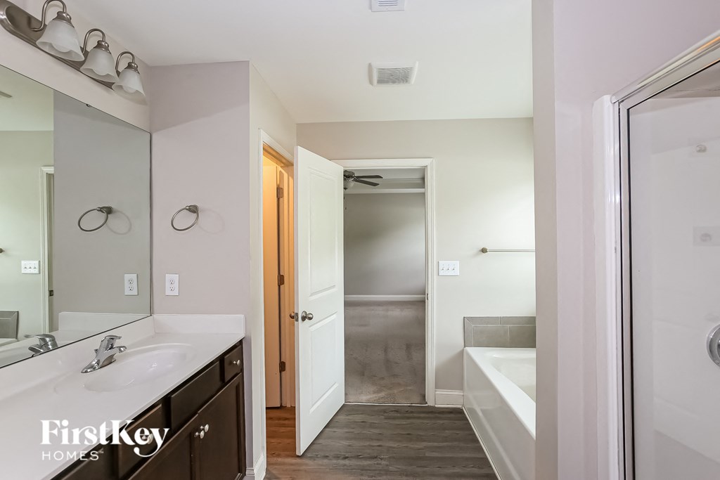 a bathroom with a large mirror and a sink and a tub
