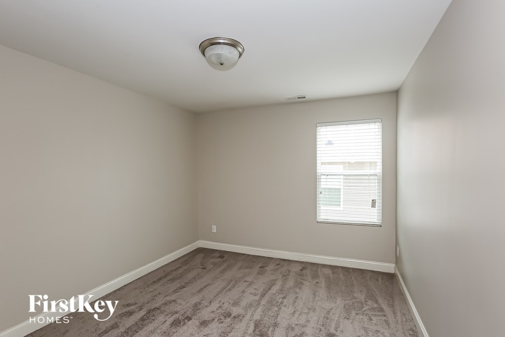 a bedroom with wood flooring and a window