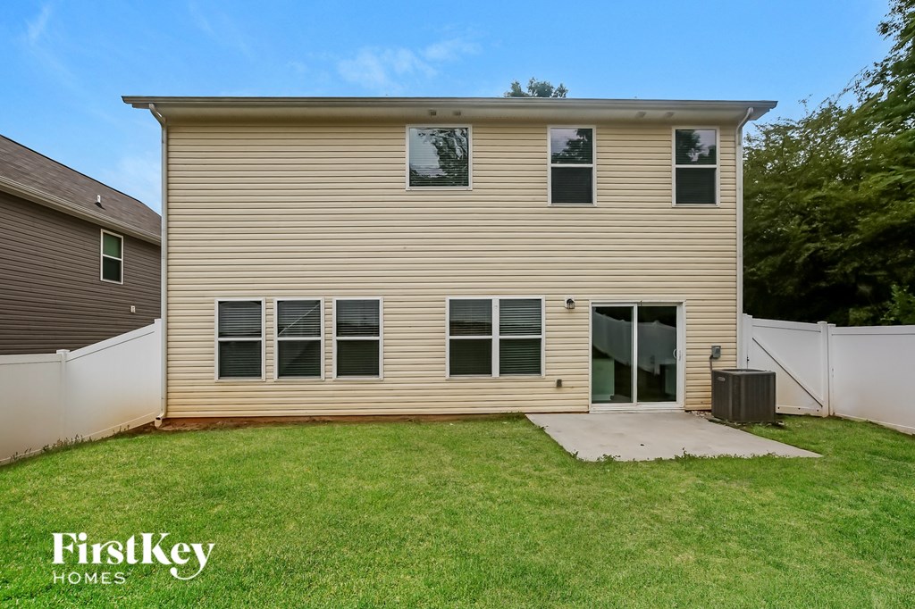 the back of a house with a yard and a backdoor